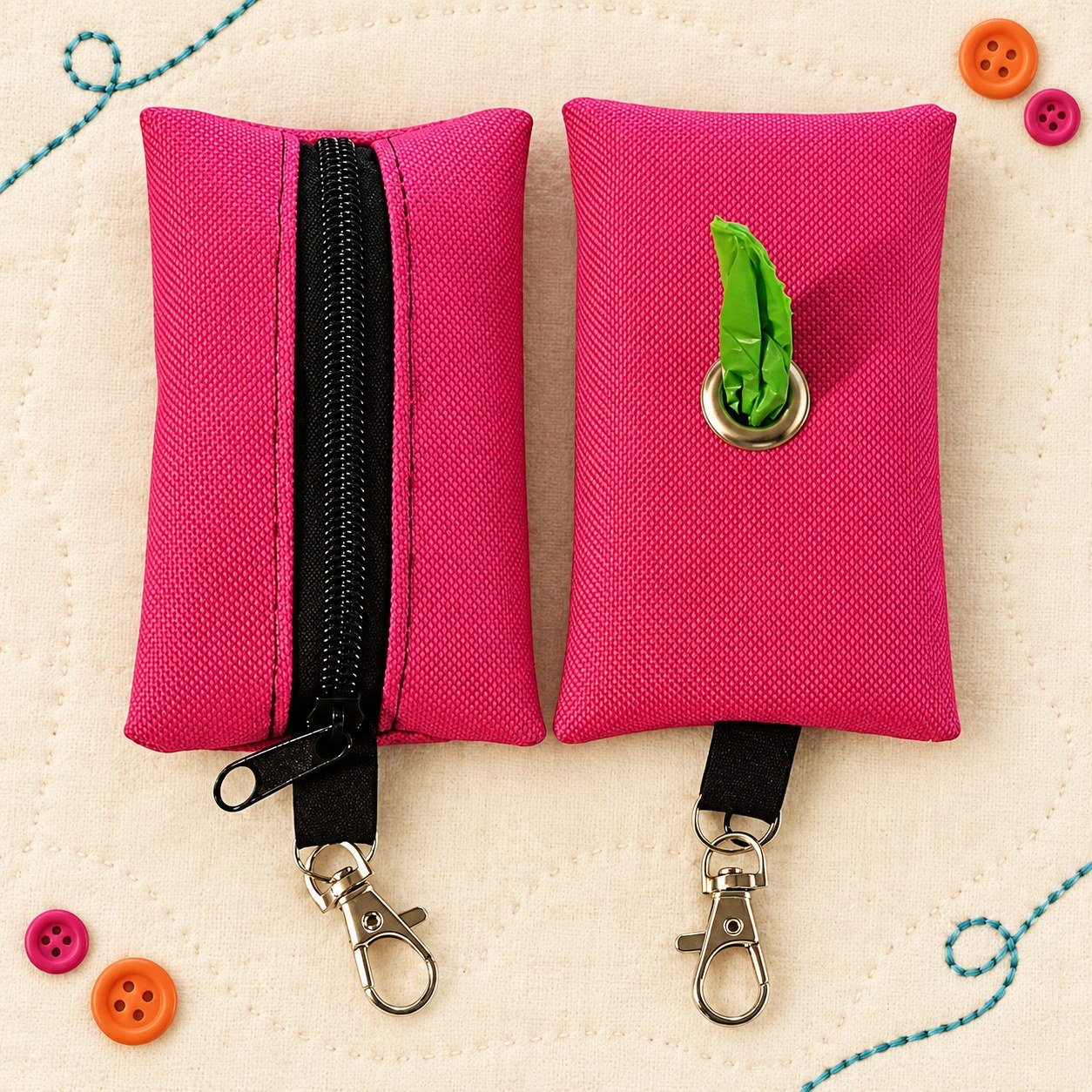 Pink zippered waste-bag holders on a cream stitched background